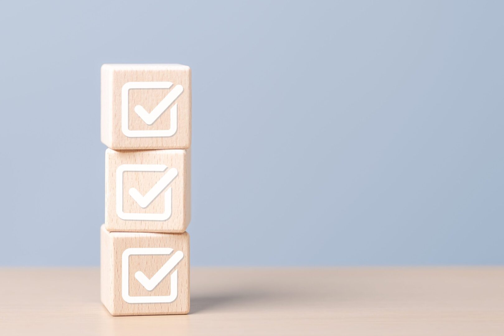 Three wooden blocks with checkmarks.