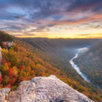 Fall foliage and a river valley at sunrise.