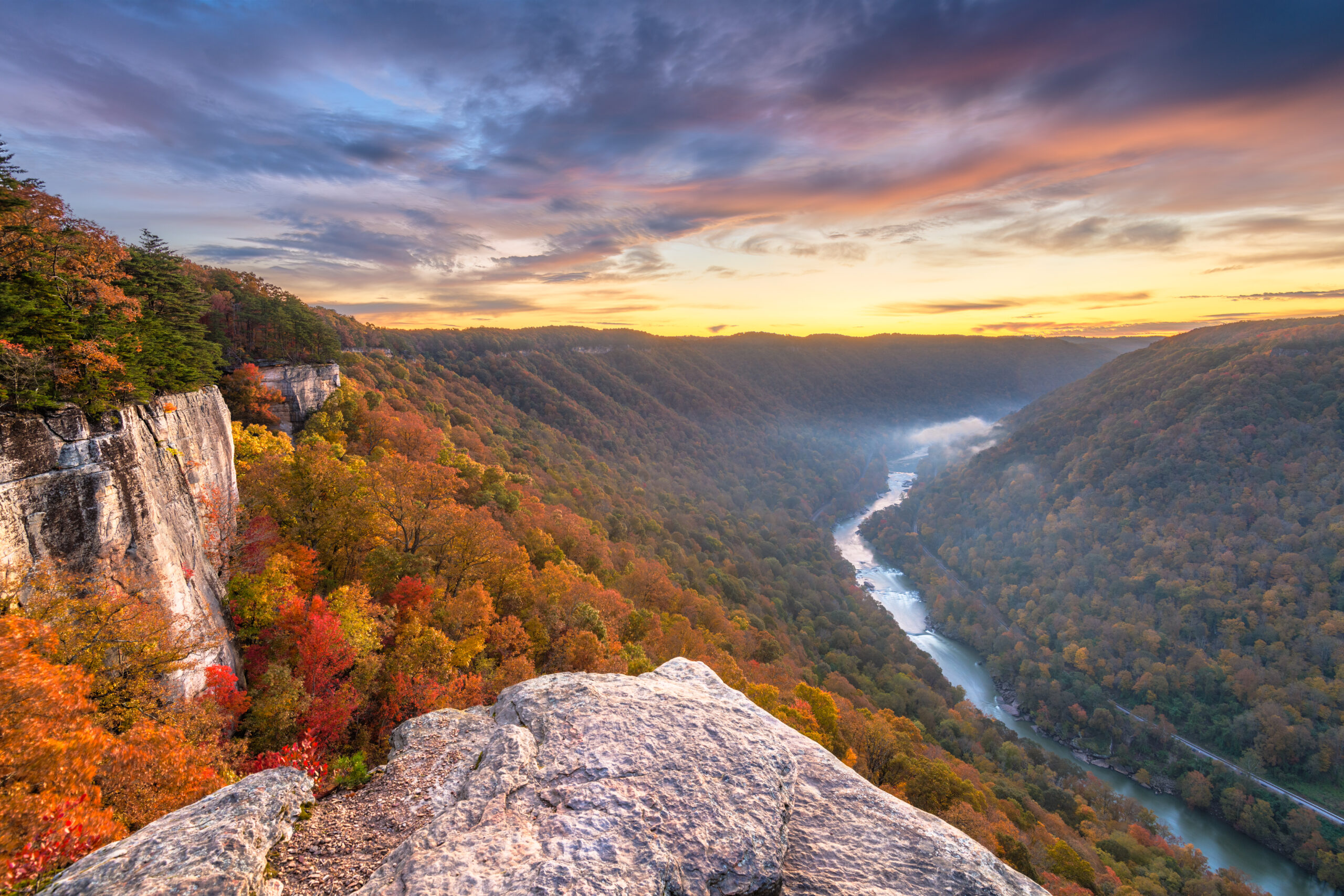 Fall foliage and a river valley at sunrise.